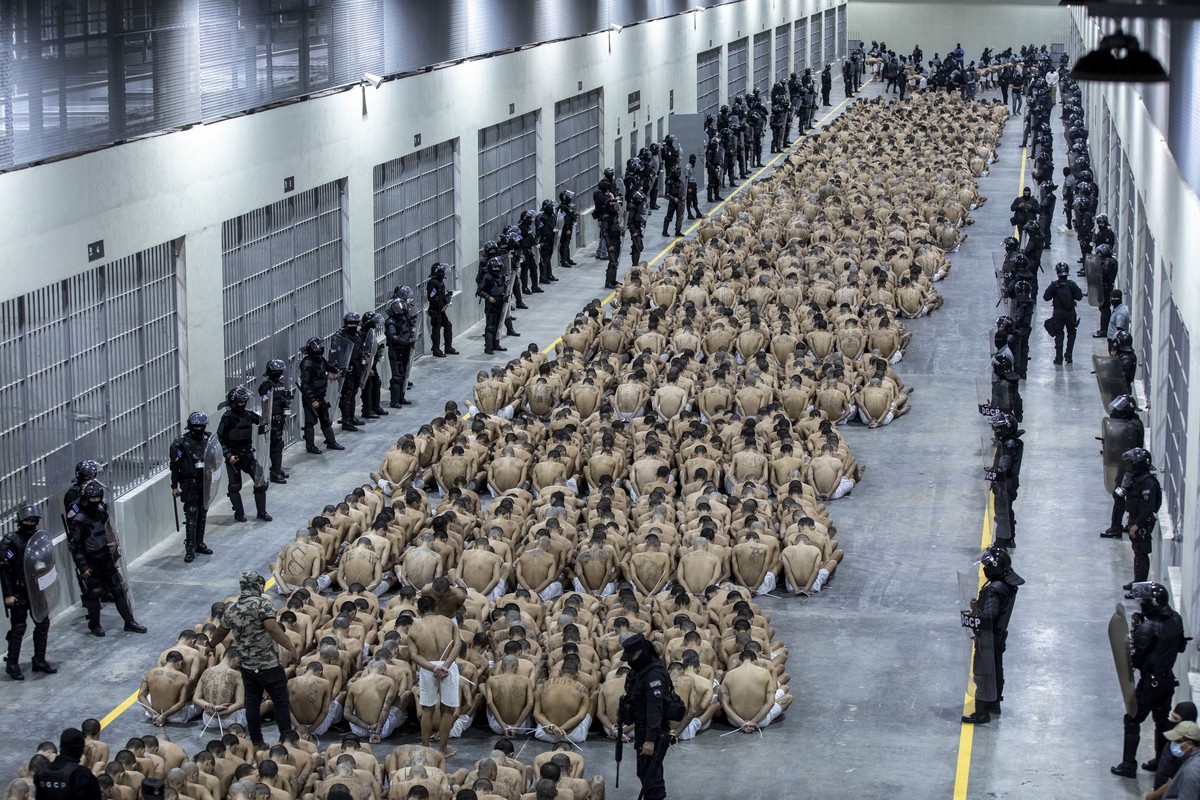 In this photo provided by El Salvador's presidential press office, inmates identified by authorities as gang members are seated on the prison floor of the Terrorism Confinement Center in Tecoluca ...