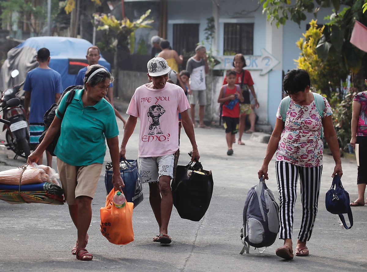 epa10680810 Filipino villagers living at the foot of Mayon volcano carry belongings during a mass evacuation in Daraga town, Albay province, Philippines, 09 June 2023. More than 20,000 residents livin ...