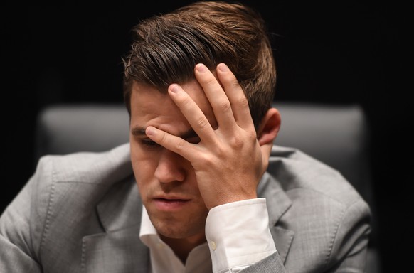 epa07177520 Norway&#039;s World Chess Champion Magnus Carlsen contemplates a move against his US challenger Fabiano Caruana (unseen) during their Round Eight game during the World Chess Championship 2 ...