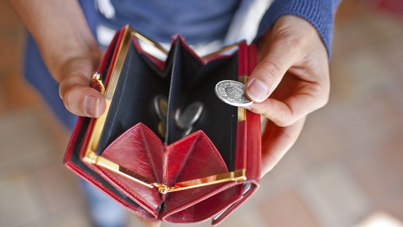 ARCHIVBILD - ZUR TASCHENGELD STUDIE STELLEN WIR IHNEN DIESES BILDMATERIAL ZUR VERFUEGUNG - A woman holds her open purse in her hands, pictured on June 10, 2009 in Zurich, Switzerland. (KEYSTONE/Gatean ...