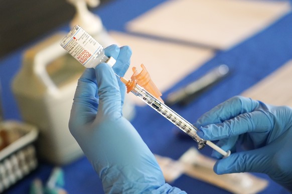 FILE - A nurse prepares a syringe of a COVID-19 vaccine at an inoculation station in Jackson, Miss., Tuesday, July 19, 2022. On Thursday, Oct. 20, 2022, a panel of U.S. vaccine experts said COVID-19 s ...