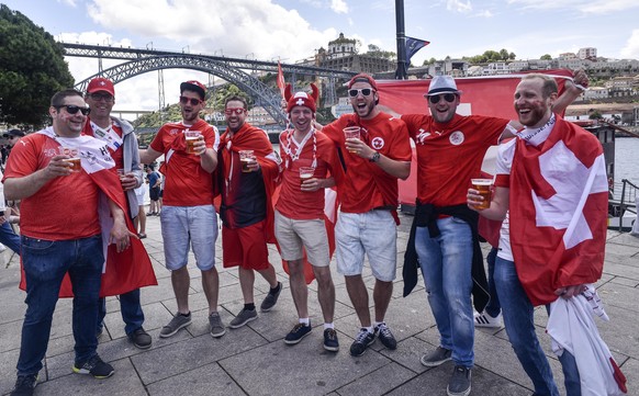 Swiss supporters drink beer in front of the Luis I Bridge landmark prior the UEFA Nations League semifinal soccer match between Portugal and Switzerland at the Dragao stadium in Porto, Portugal, Wedne ...