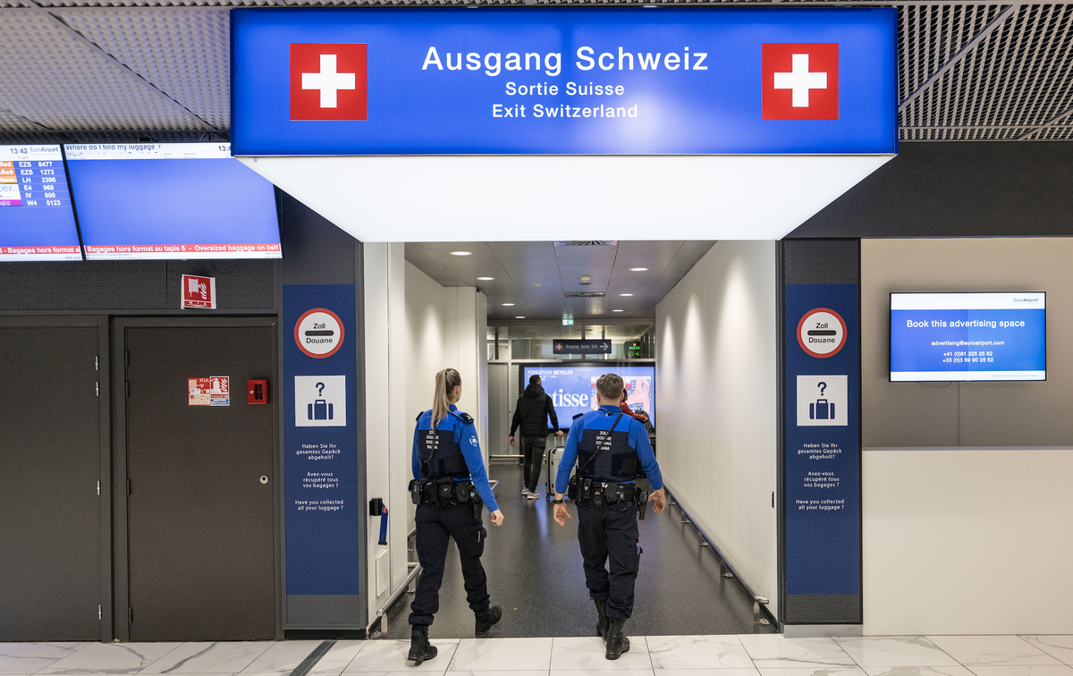 Des agents de l'Office fédéral des douanes et de la sécurité aux frontières (BAZG) contrôlent des voyageurs à l'Euroairport Bâle-Mulhouse, photo prise le mardi 15 octobre 2024. (KEYSTONE/Chr ...