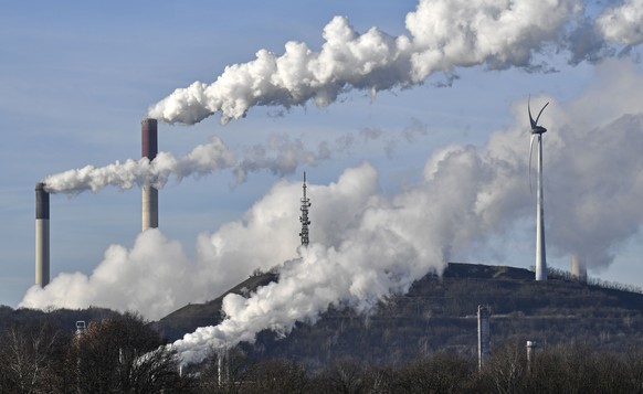 A Uniper coal-fired power plant and BP refinery steam beside a wind generator in Gelsenkirchen, Germany, Thursday, Jan. 16, 2020. The German government says officials have agreed on a plan to shut dow ...