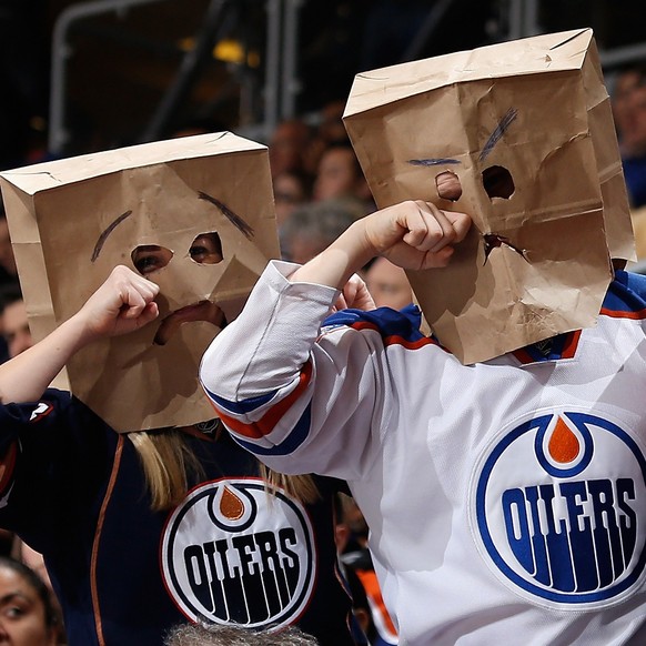 GLENDALE, AZ - DECEMBER 16: Fans of the Edmonton Oilers wearing bags on their heads react during the NHL game against the Arizona Coyotes at Gila River Arena on December 16, 2014 in Glendale, Arizona. ...