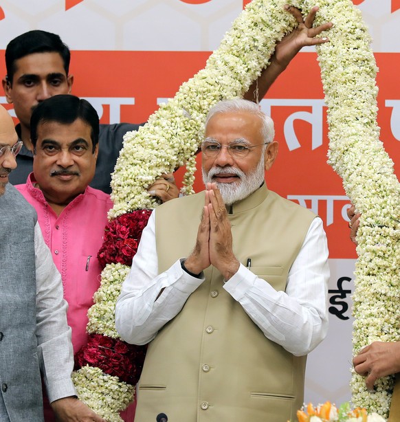 epa07589358 Bhartya Janta party (BJP) leader and Indian Prime Minister Narendra Modi (C ) is greeted by the BJP president Amit shah (L) and senior leader Raj Nath Singh at the party headquarters in Ne ...