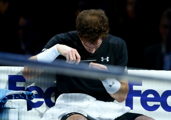 LONDON, ENGLAND - NOVEMBER 18: Andy Murray of Great Britain cuts his hair in-between games in his men&#039;s singles match against Rafael Nadal of Spain during day four of the Barclays ATP World Tour  ...