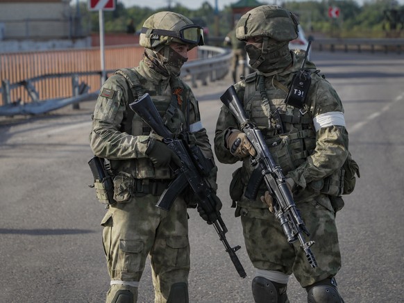 epa09962109 A picture taken during a media tour organized by the Russian Army shows Russian servicemen standing guard near the Kakhovka Hydroelectric Power Plant (HPP) on the Dnieper River in Kakhovka ...
