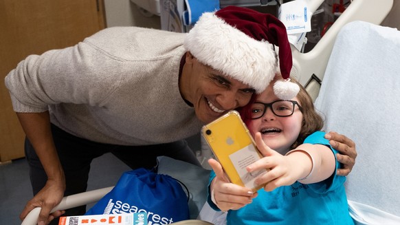 epa07241284 A handout photo made available by the Office of President Barack Obama shows former President Barack Obama (L) taking a photo with a patient at the Children&#039;s National Medical Center  ...