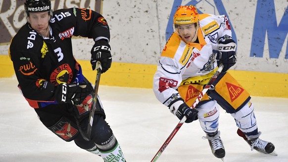 Der Zuger Topssorer Lino Martschini, rechts, und der Berner Justin Krueger, links, waehrend dem Eishockey-Meisterschaftsspiel der National League A zwischen dem SC Bern und dem EV Zug, am Dienstag, 21 ...