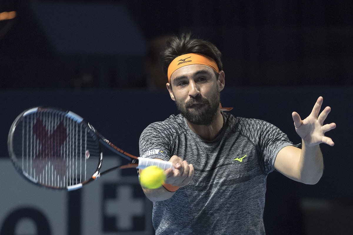 Cyprus' Marcos Baghdatis returns a ball to Belgium's David Goffin during their first round match at the Swiss Indoors tennis tournament at the St. Jakobshalle in Basel, Switzerland, on Tuesd ...