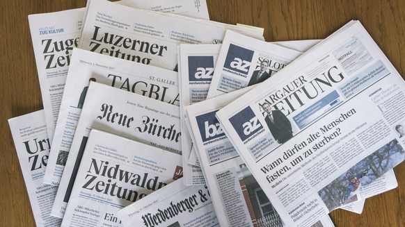 ARCHIV - ZUM ZUSAMMENSCHLUSS DER AZ MEDIEN UND DER NZZ-MEDIENGRUPPE STELLEN WIR IHNEN DIESES ARCHIVBILD ZUR VERFUEGUNG - Zeitungen der AZ Medien und der NZZ Mediengruppe liegen auf einem Tisch, am Mit ...