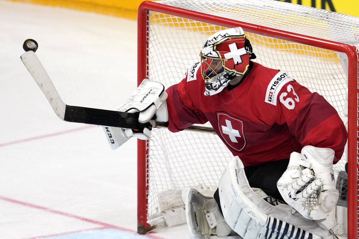 Switzerland's goalkeeper Leonardo Genoni deflects a shot during the gold medal match between Czech Republic and Switzerland at the Ice Hockey World Championships in Prague, Czech Republic, Sunday ...