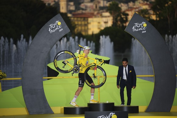 Tour de France winner Slovenia&#039;s Tadej Pogacar, wearing the overall leader&#039;s yellow jersey, walks onto the podium after the twenty-first stage of the Tour de France cycling race, an individu ...