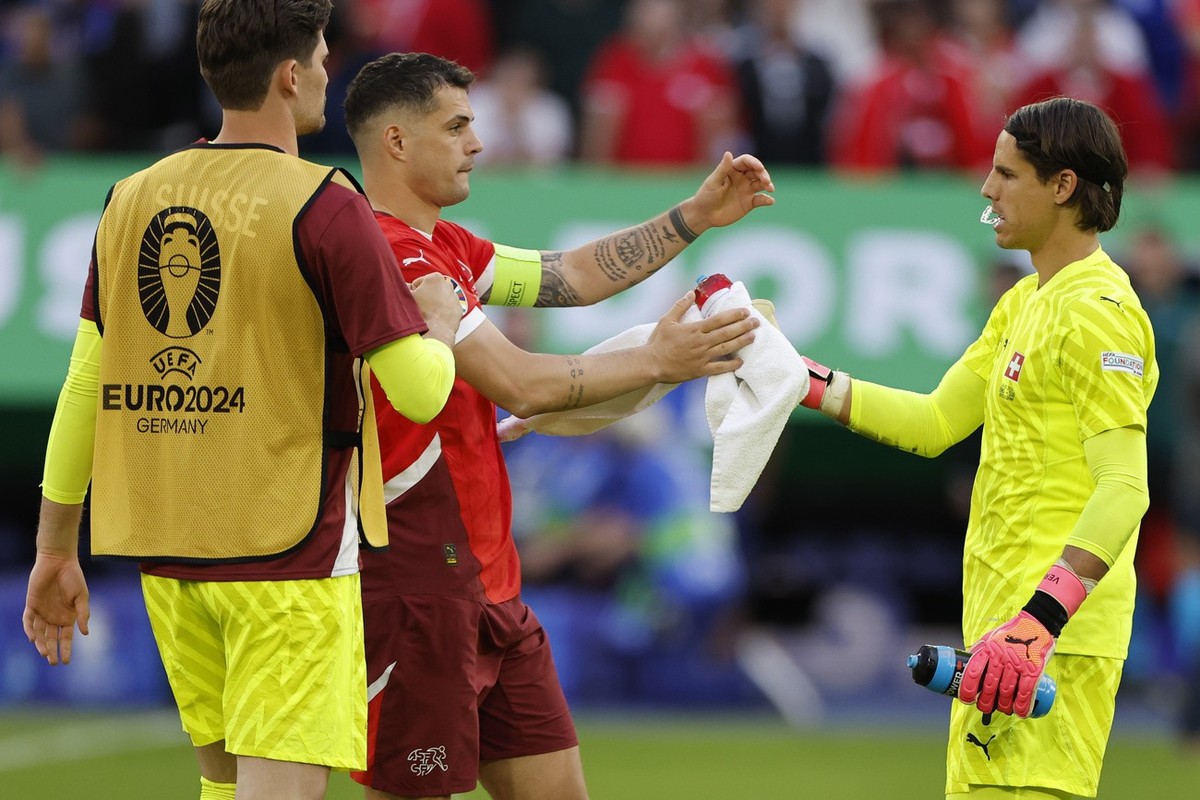 Switzerland's Yann Sommer, right, Granit Xhaka, center, and Gregor Kobel, left, react after losing the penalty shoot-out of the quarter final match between England and Switzerland at the Euro 202 ...
