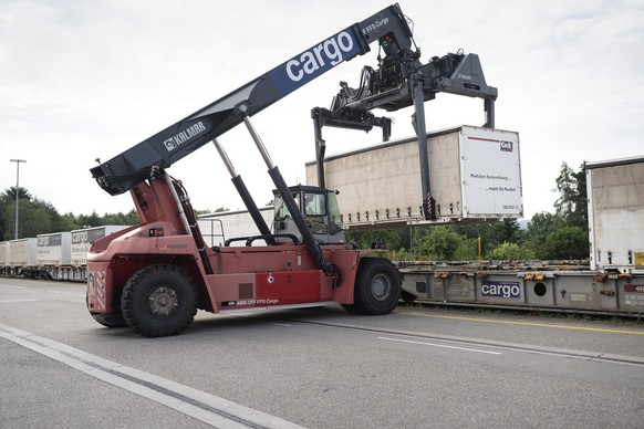 A mobile crane is used to unload containers from rail trucks at the Swiss Federal Railways Cargo transfer terminal in Dietikon, Switzerland, on June 21, 2019. (KEYSTONE/Gaetan Bally ...