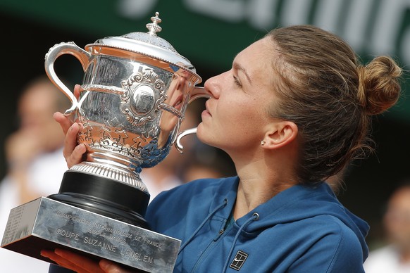 FILE - In this Saturday, June 9, 2018 file photo, Romania&#039;s Simona Halep holds the trophy and celebrates winning the final match of the French Open tennis tournament against Sloane Stephens of th ...