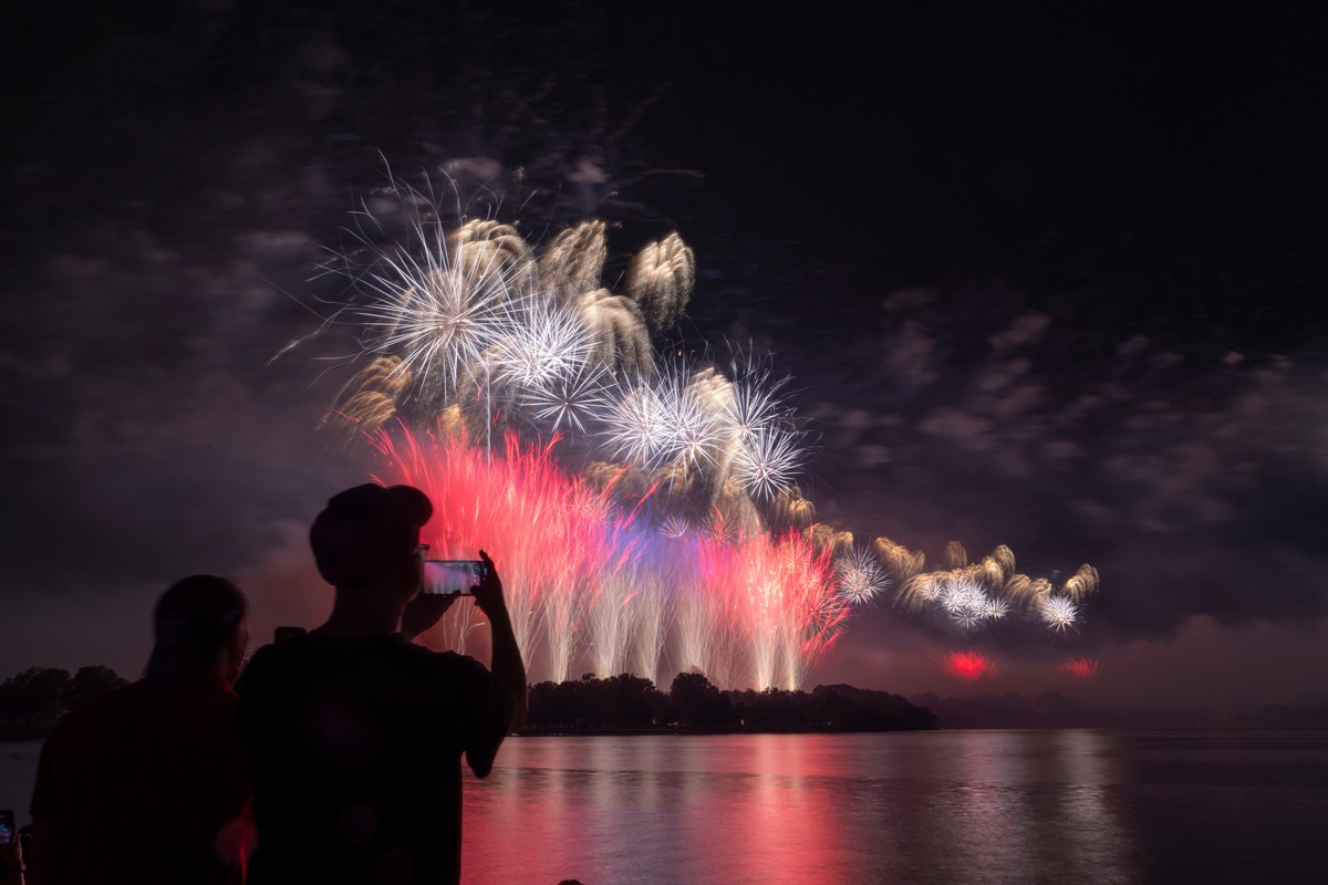 Spectators record the firework show during an Independence Day event honoring the nation's 250th anniversary, Sunday, July 5, at the Jefferson Memorial in Washington. (AP Photo/Tallulah Brown Van ...