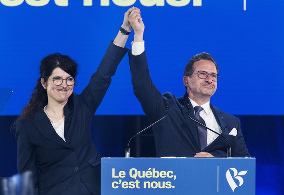 Bloc Quebecois leader Yves-Francois Blanchet has his hand raised by wife Nancy Deziel as he speaks to supporters on federal election night in Montreal, early Tuesday, Oct. 22, 2019. (Graham Hughes/The ...