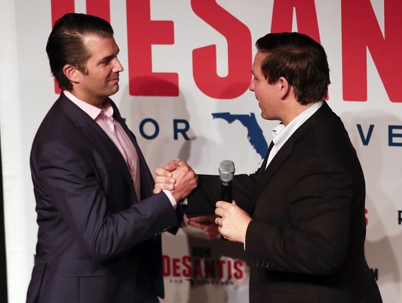 Donald Trump Jr., left, greets Florida gubernatorial candidate U.S. Rep. Ron DeSantis at a campaign rally Wednesday, July 18, 2018, in Orlando, Fla. (AP Photo/John Raoux)