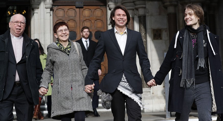 Lauri Love smiles as he leaves with parents Alexander Love, left, Sirkka-Liisa Love, second left, and girlfriend Sylvia Mann, from The Royal Courts of Justice in London, Monday, Feb. 5, 2018. The ruli ...