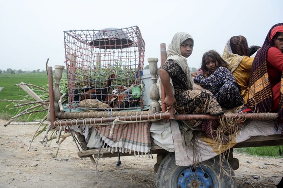 epa10815575 People ride a cart with their belongings as they evacuate a flooded area in Noora Nath, Pakpattan district, Punjab province, Pakistan, 23 August 2023. Around 100,000 people have been evacu ...