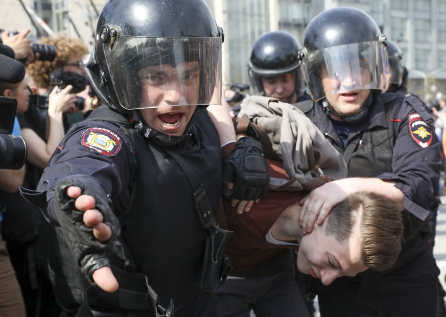 Russian police detain a protester at a demonstration against President Vladimir Putin in Pushkin Square, Moscow, Saturday May 5, 2018. Police arrested hundreds, including protest organizer Alexei Nava ...