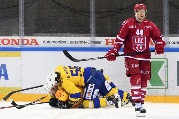 Les joueurs davosiens laissent eclater leur joie apres le 3eme but devant la deception de l&#039;attaquant lausannois Nicklas Danielsson, droite, lors du 1er match du quart de finale de play off du ch ...