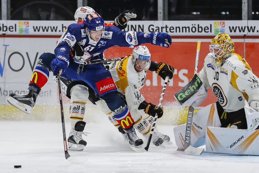 Der Zuercher Fabrice Herzog, links, gegen Luganos Stefan Ulmer, Mitte, und Luganos Goalie Elvis Merzlikins, waehrend dem Eishockey-Meisterschaftsspiel der National League zwischen den ZSC Lions und de ...