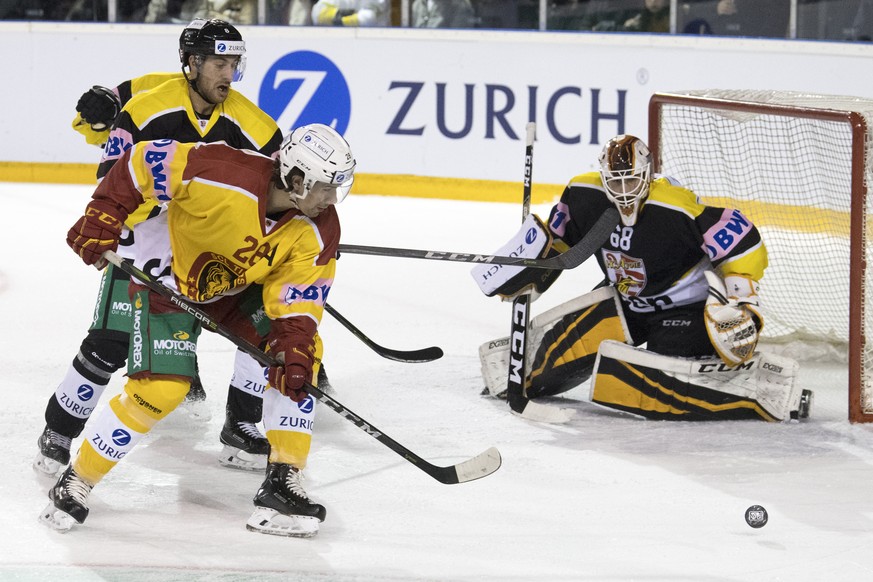 Ajoies Philip-Michael Devos, links, und Goalie Dominic Nyffeler im Kampf um den Puck gegen Tigers Yannick-Lennart Albrecht, Mitte, waehrend dem Swiss Ice Hockey Cup Viertelfinal zwischen dem HC Ajoie, ...