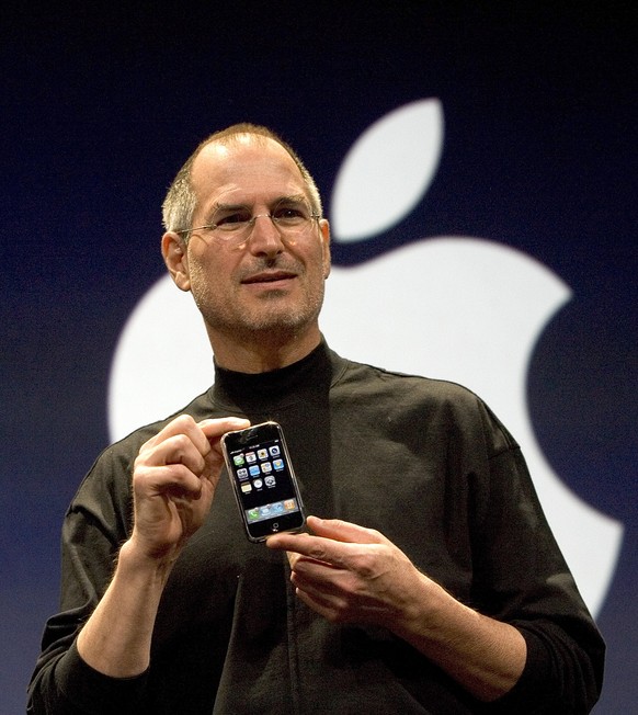 SAN FRANCISCO, CA - JANUARY 9: Apple CEO Steve Jobs holds up the new iPhone that was introduced at Macworld on January 9, 2007 in San Francisco, California. During the keynote Jobs introduced the new  ...