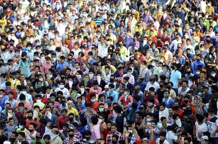 Migrant workers shout slogans during a protest against the the extension of the lockdown, at a slum in Mumbai, India, Tuesday, April 14, 2020. Indian Prime Minister Narendra Modi on Tuesday extended t ...