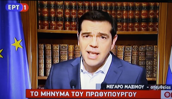 In this photo taken from television Greece's Prime Minister Alexis Tsirpas delivers a televised address to the nation from his office at Maximos Mansion in Athens, Wednesday, July 1, 2015. Tsipras has vowed to push on with his plan for a referendum this Sunday on the recent proposals from the country's creditors. The banner reads ''The statement of the Prime Minister.'' (AP Photo/Thanassis Stavrakis) 
