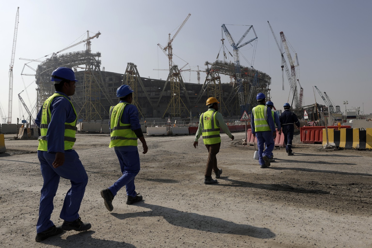 Workers walk to the Lusail Stadium, one of the 2022 World Cup stadiums, in Lusail, Qatar, Dec. 20, 2019. A former CIA officer who spied on Qatar