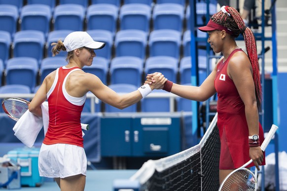 Viktorija Golubic of Switzerland, left, and Naomi Osaka of Japan shake hands after their women&#039;s single tennis second round match at the 2020 Tokyo Summer Olympics at the Ariake Tennis Park in To ...