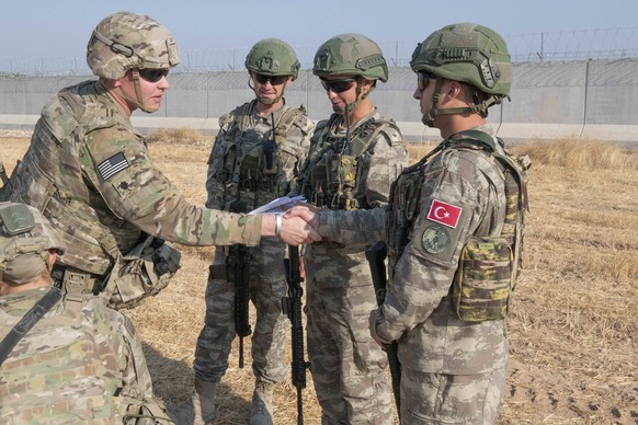 epa07903001 A handout photo made available by the US Army shows US and Turkish military forces conducting the third ground combined joint patrol inside the security mechanism area in northeast Syria,  ...