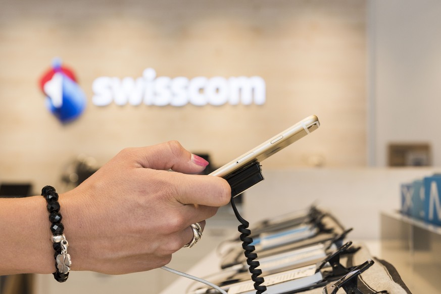 ZUM THEMA SWISSCOM STELLEN WIR IHNEN FOLGENDES ARCHIVBILD ZUR VERFUEGUNG - A customer tests a mobile phone at a Swisscom Shop of the telecommunications provider Swisscom AG on Avenue Bergieres 42 in L ...