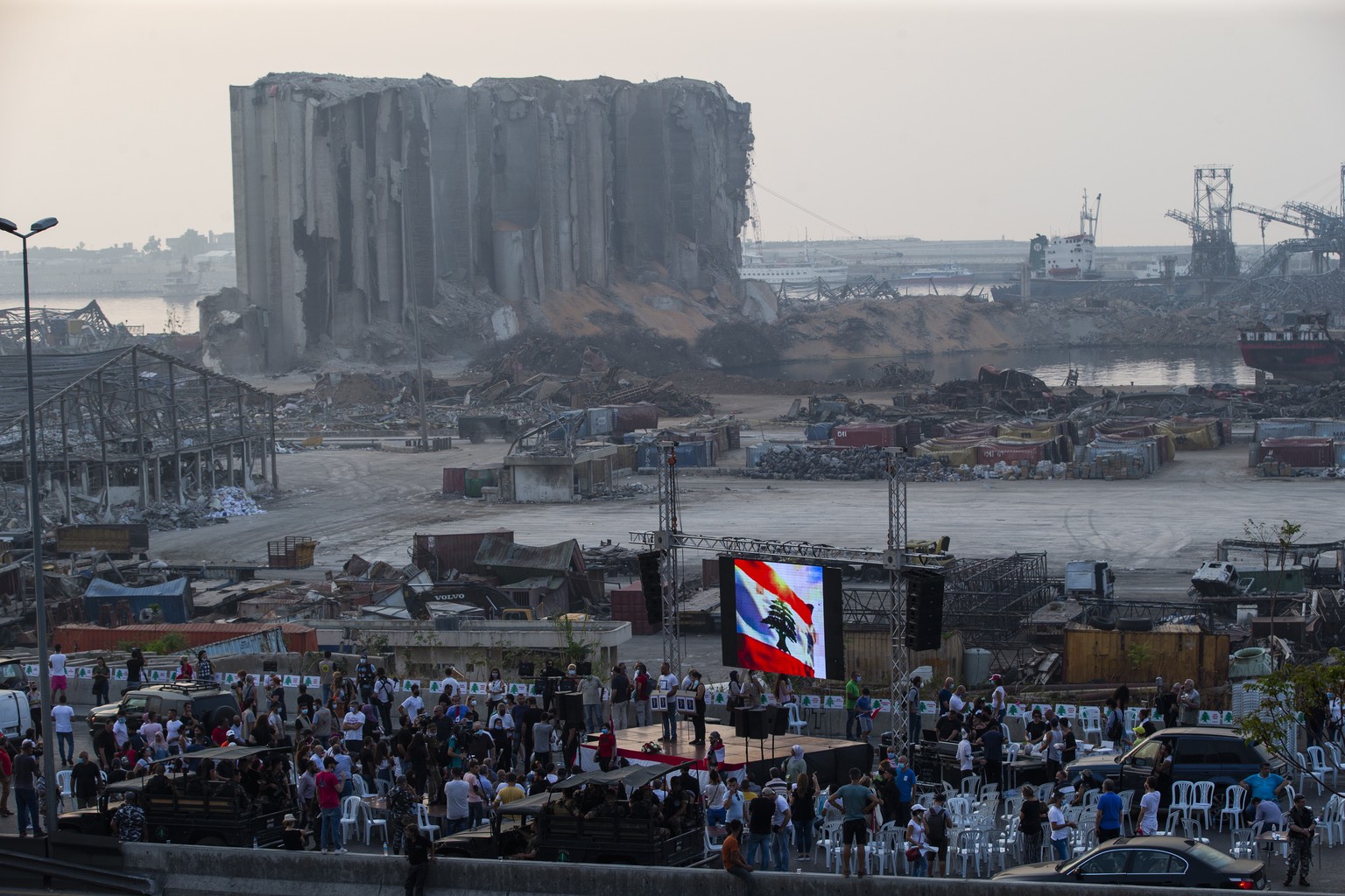 epa08647628 A general view showing families of Beirut port explosion victims carrying their pictures, during a minute of silence and prayer to mark one month of Beirut port explosion, in front the Bei ...