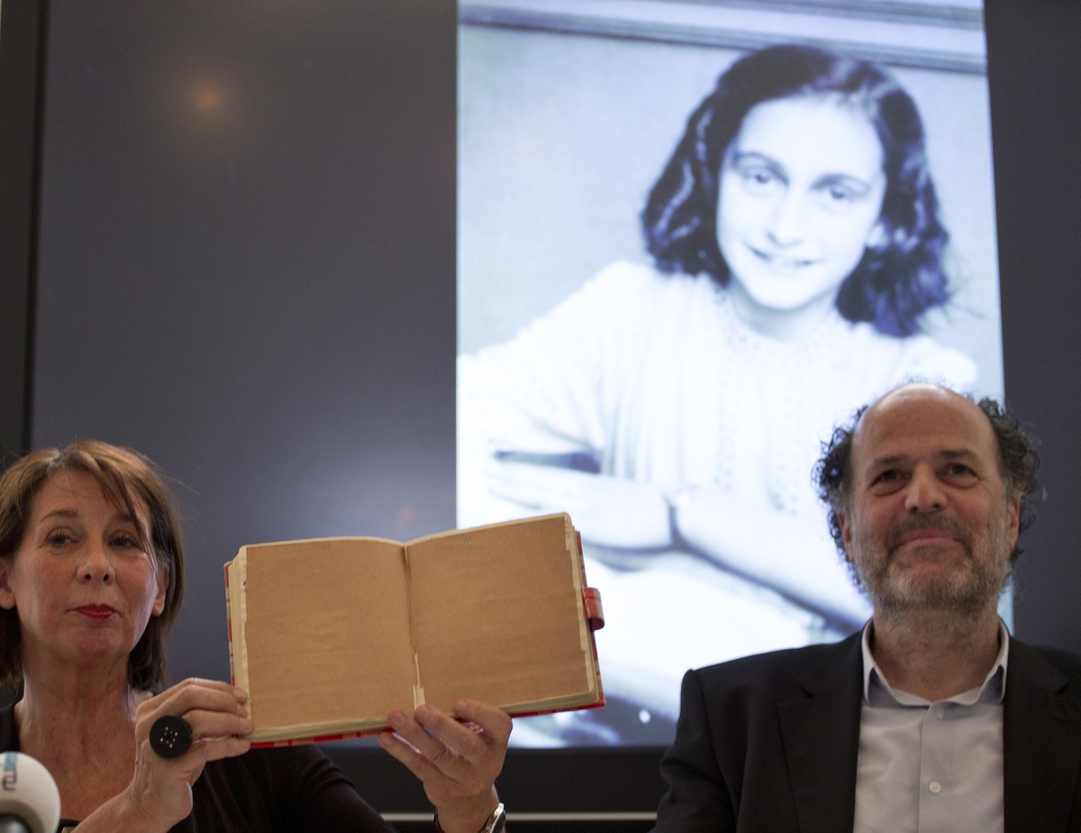 Teresien da Silva, left, and Ronald Leopold of the Anne Frank Foundation show a facsimile of Anne Frank's diary with two pages taped off during a press conference at the foundation's office  ...