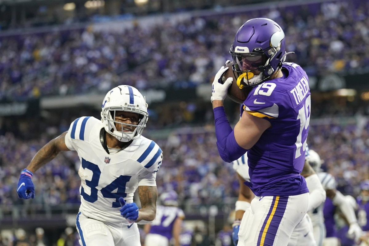 Minnesota Vikings wide receiver Adam Thielen (19) catches a 1-yard touchdown pass ahead of Indianapolis Colts cornerback Isaiah Rodgers (34) during the second half of an NFL football game, Saturday, D ...