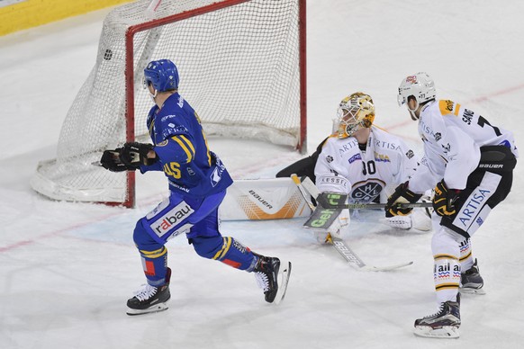 Der Davoser Gregory Sciaroni, links, bei seinem Anschlusstreffer zum 1:2 gegen Lugano&#039;s Goalie Elvis Merkzlikins (LV) und Bobby Sanguinetti, beim Eishockey Meisterschaftsspiel in der Qualifikatio ...