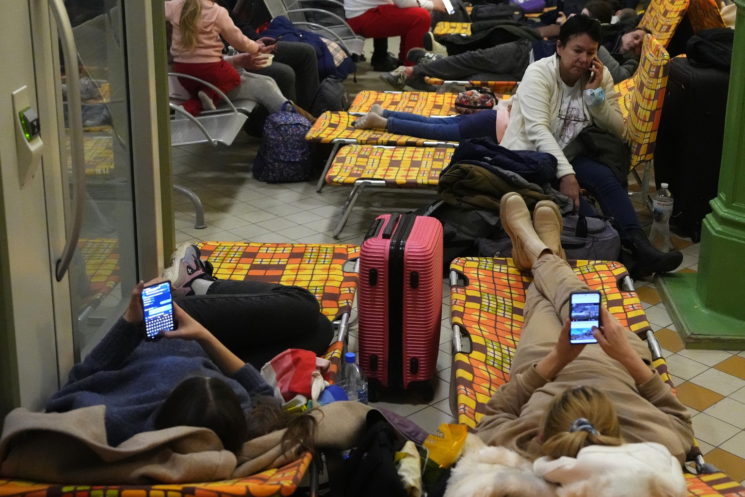 People from neighboring Ukraine, rest at a train station that was turned into an accommodation center in Przemysl, Poland, on Thursday, Feb. 24, 2022. Russia launched a wide-ranging attack on Ukraine  ...