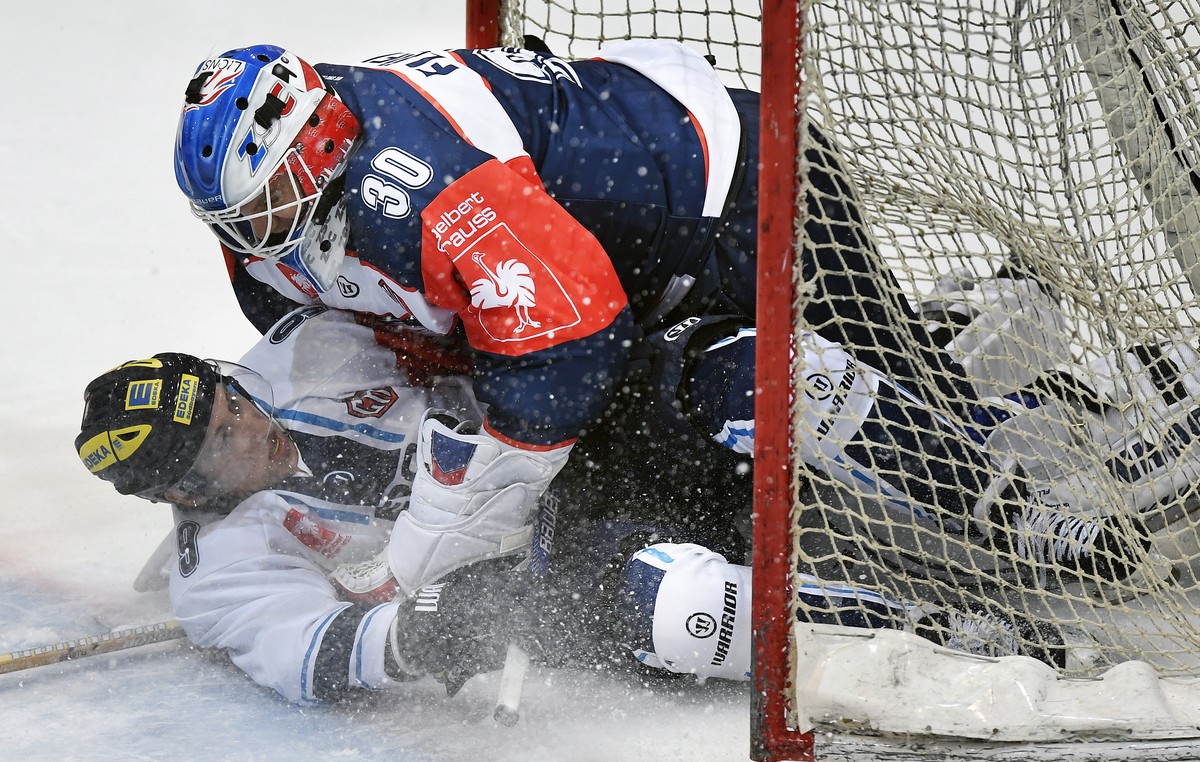Zurich's goalkeeper Lukas Flueeler, right, fights with Ingolstadt's Brandon Buck, left, during the Champions Hockey League Group D hockey match between Switzerland's ZSC Lions and Germa ...