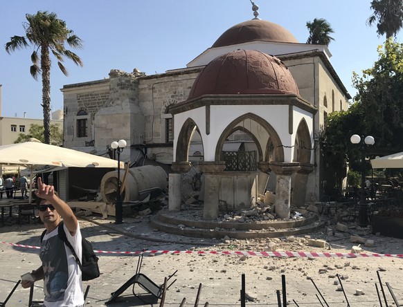 A man gestures in front of the toppled minaret of a mosque after an earthquake in Kos on the island of Kos, Greece Friday, July 21, 2017. Greek authorities said two tourists killed in the overnight qu ...