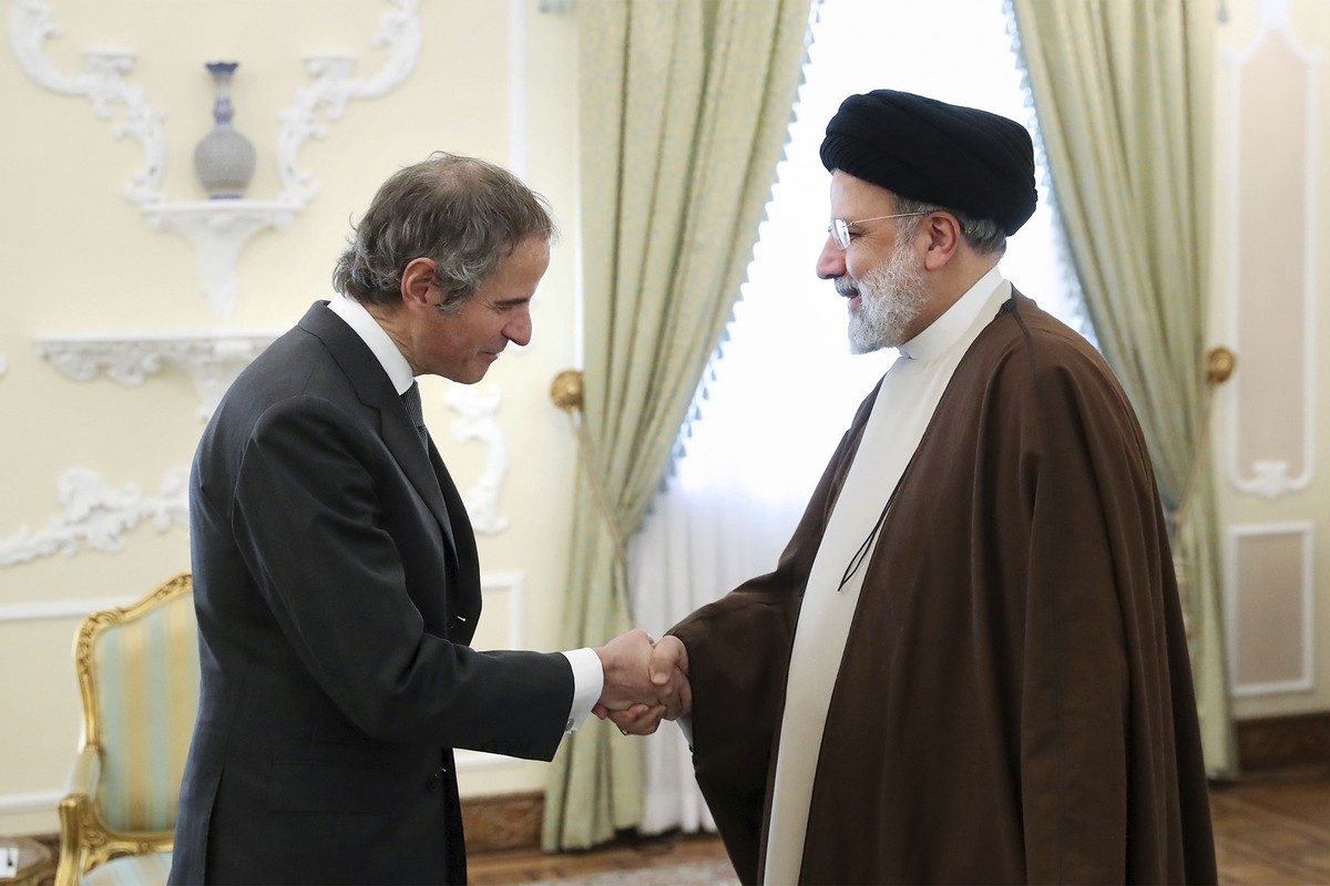 In this photo released by the official website of the office of the Iranian Presidency, President Ebrahim Raisi, right, shakes hands with International Atomic Energy Organization, IAEA, Director Gener ...