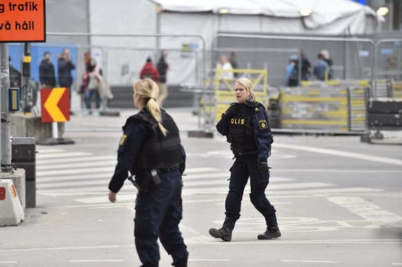 epa05894582 Swedish police officers guard the area after a truck reportedly crashed into a department store in central Stockholm, Sweden, 07 April 2017. A truck has driven into crowds on a street in c ...