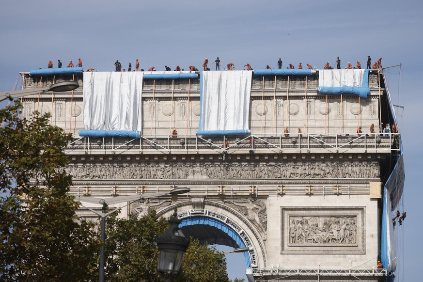 Workers wrap the Arc de Triomphe monument, Sunday, Sept. 12, 2021 in Paris. The &quot;L&#039;Arc de Triomphe, Wrapped&quot; project by late artist Christo and Jeanne-Claude will be on view from, Sept. ...