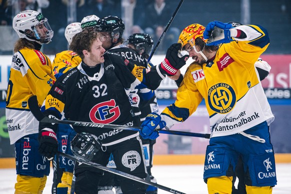 L?attaquant fribourgeois Lucas Wallmark, gauche, se bat avec le top scorer PostFinance davosien Matej Stransky, droite, lors du match du championnat suisse de hockey sur glace de National League entre ...