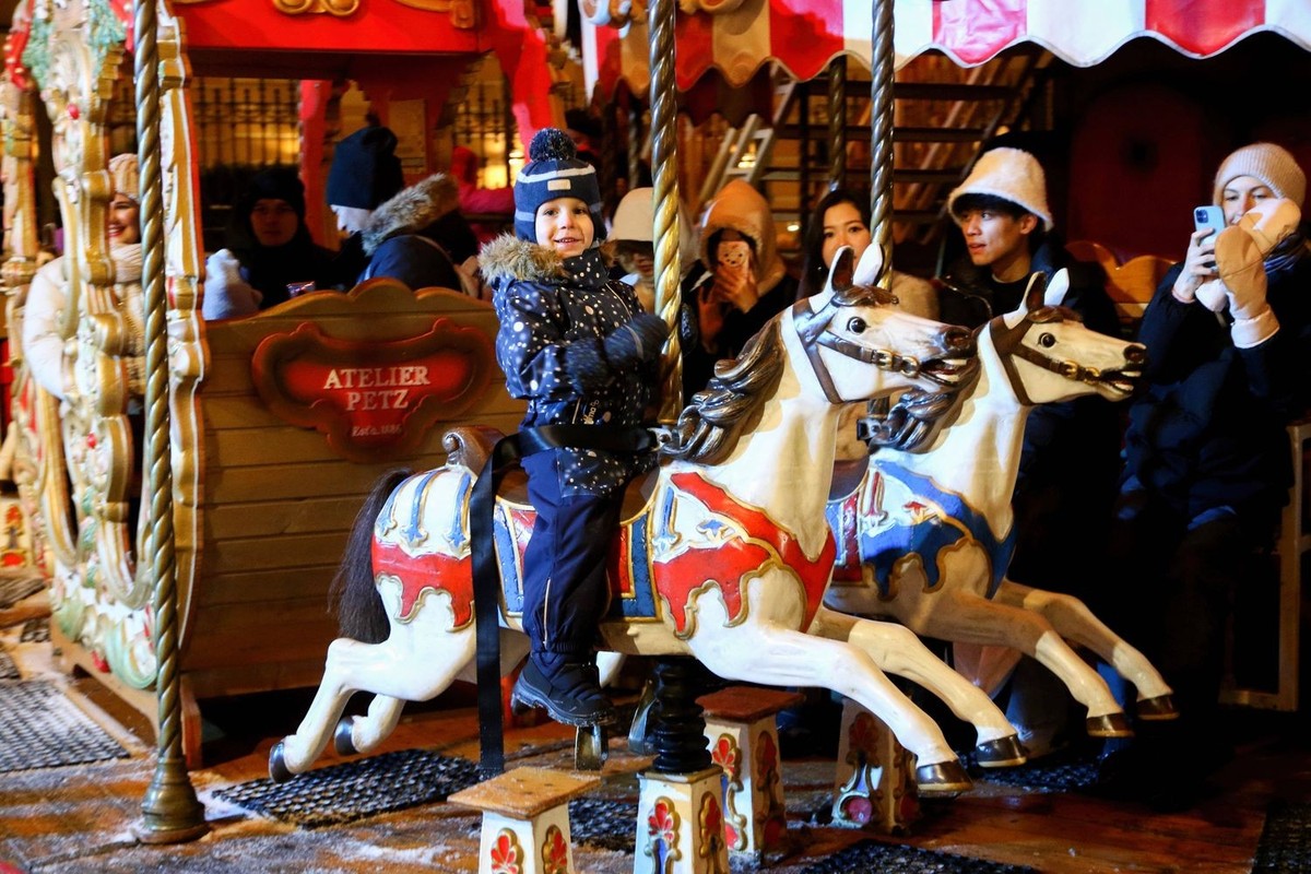 Christmas Market in Saint Petersburg, Russia - 26 Dec 2923 A boy rides a horse, on a grandiose two-story carousel on Manezhnaya Square at the Christmas Market in honor of the New Year and Christmas. S ...
