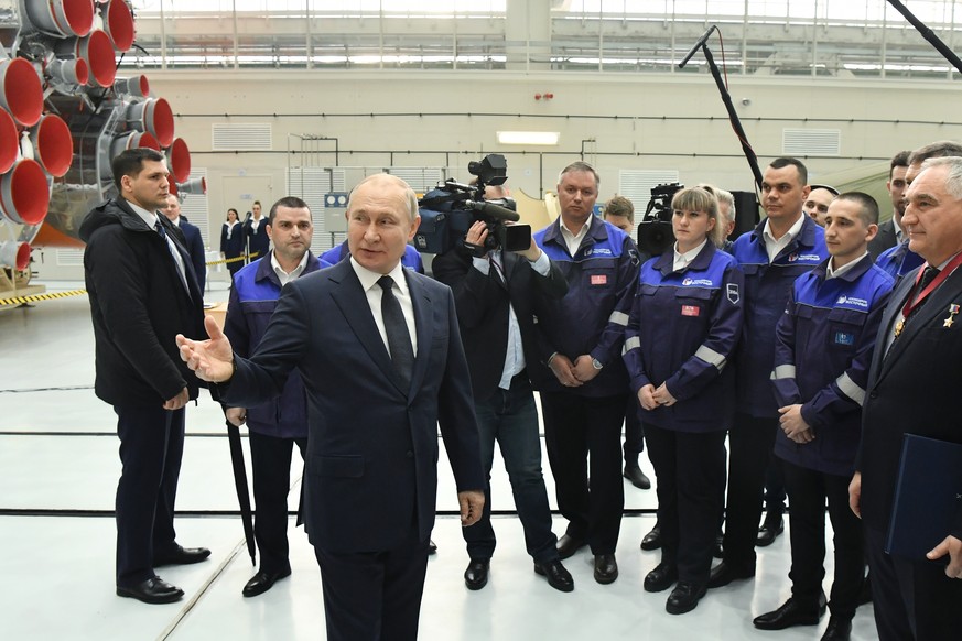 epa09885740 Russian President Vladimir Putin (front) speaks with employees at the Vostochny cosmodrome outside the city of Tsiolkovsky, some 180 km north of Blagoveschensk, in the far eastern Amur reg ...